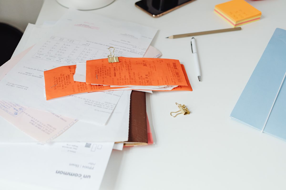 Aufgeräumter Schreibtisch mit Belegen, Quittungen und Büromaterial als Symbol für organisierte digitale Buchhaltung