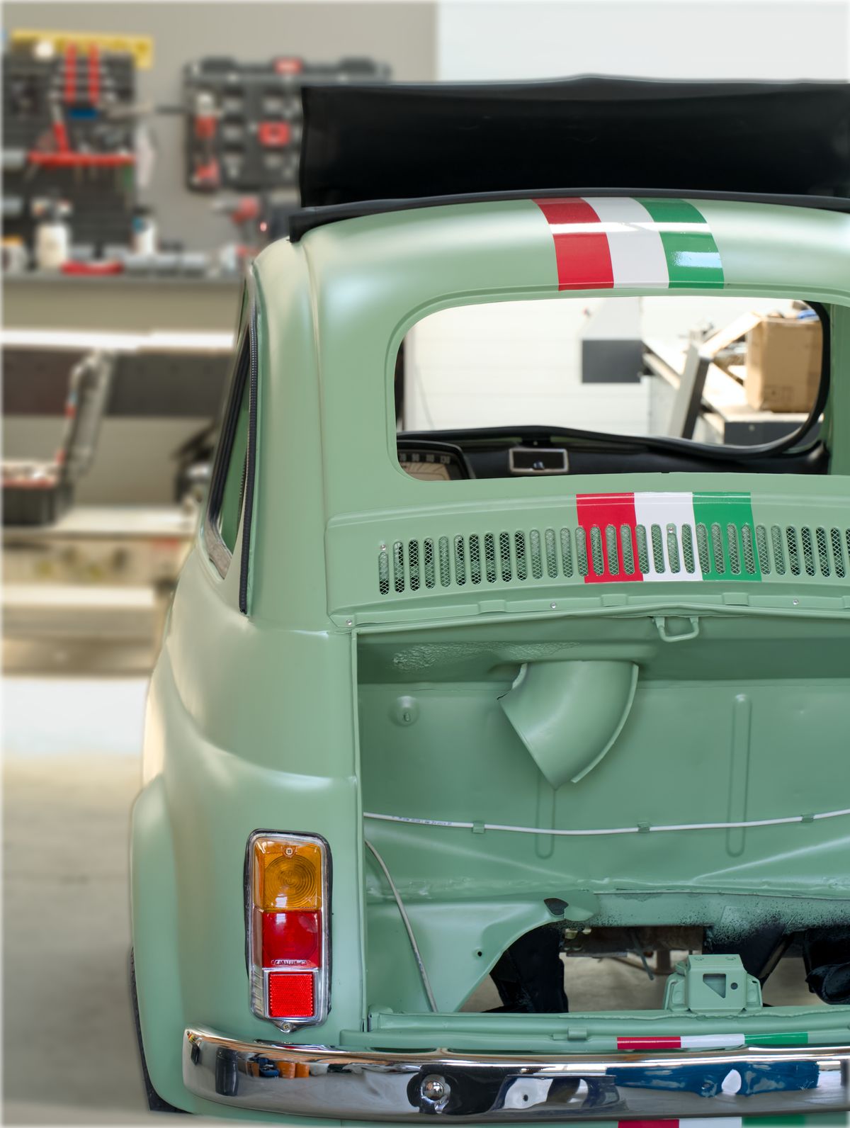 Kfz-Mechaniker restauriert einen Oldtimer in einer gut ausgestatteten Werkstatt