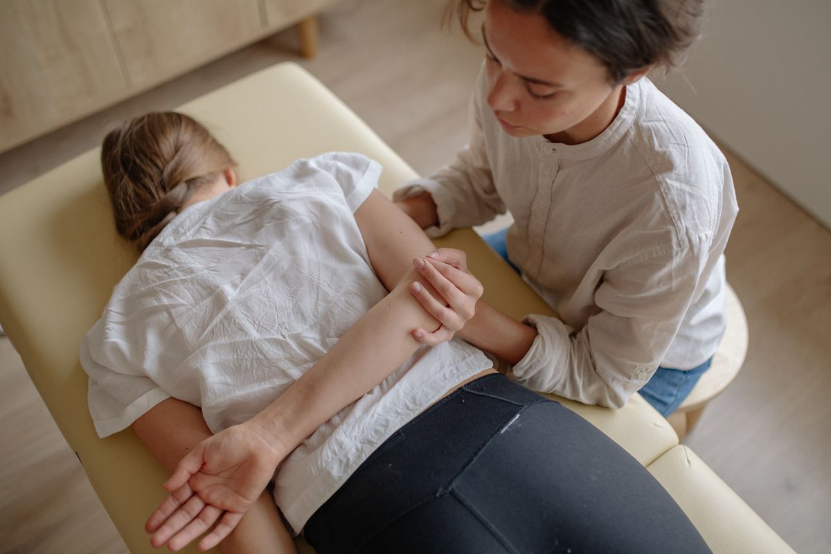 Chiropraktikerin behandelt den Rücken einer Patientin auf der Behandlungsliege
