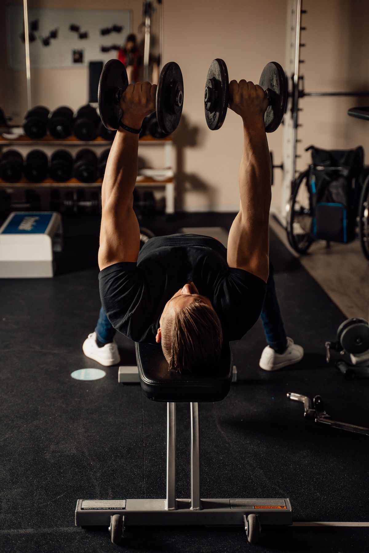 Mann trainiert mit Kurzhanteln im Fitnessstudio