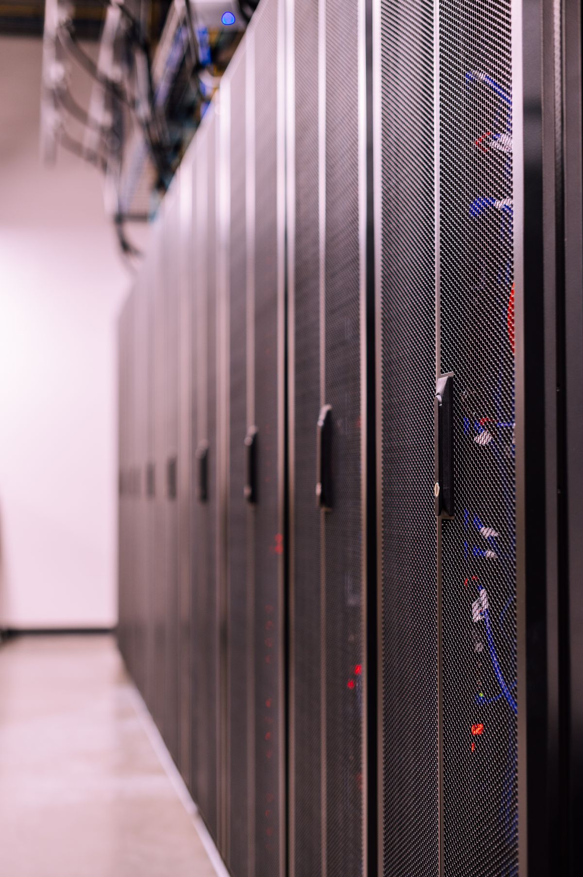 Reihen von Server-Racks mit Netzwerkkabeln in einem Rechenzentrum