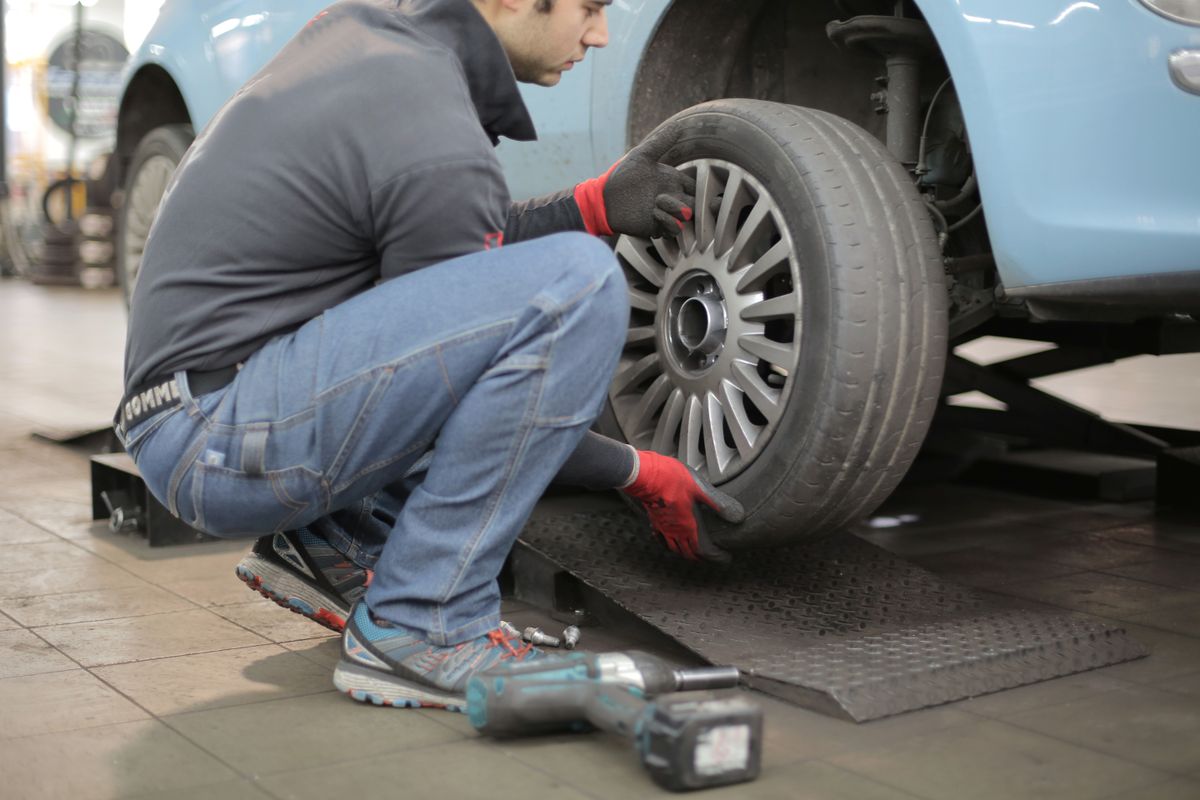 Mechaniker wechselt einen Autoreifen in der Werkstatt